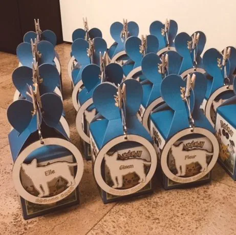 Houten hangers met kindernamen aan traktatiedoosjes