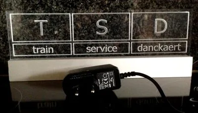 Verlicht plexi bord met de letters T S D, met de voeding ervoor